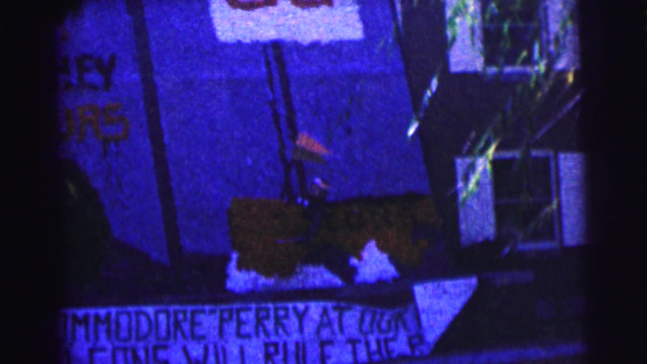 Blue-tinted frame of hand-painted signs beside a dark building exterior and white-trimmed window.