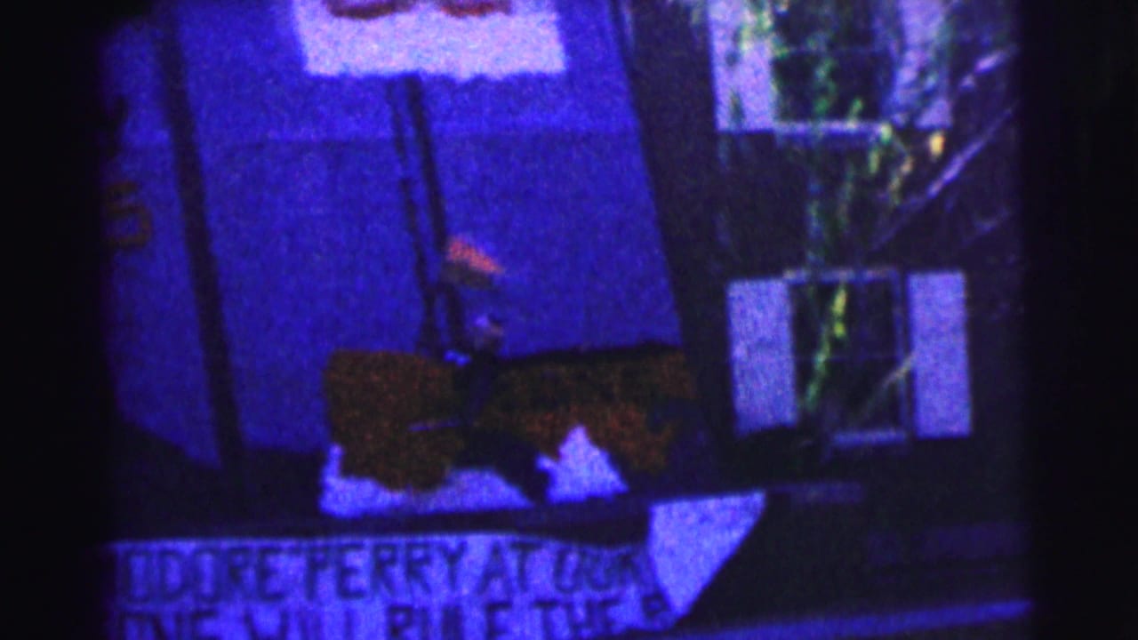 1963 Bowling Green University frame with partially readable hand-painted signs below a building window in low light.