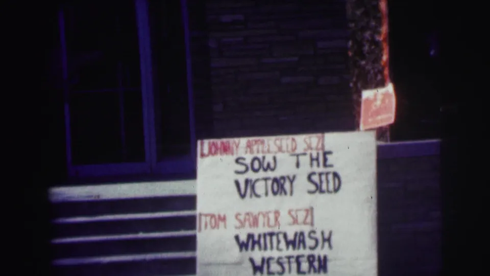 Nighttime 8mm frame at Bowling Green University with a handmade sign including Sow the Victory Seed and Whitewash Western text.