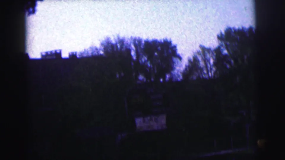Final Bowling Green University clip frame showing a shadowed stadium perimeter, trees, sky, and a distant sign-like element.