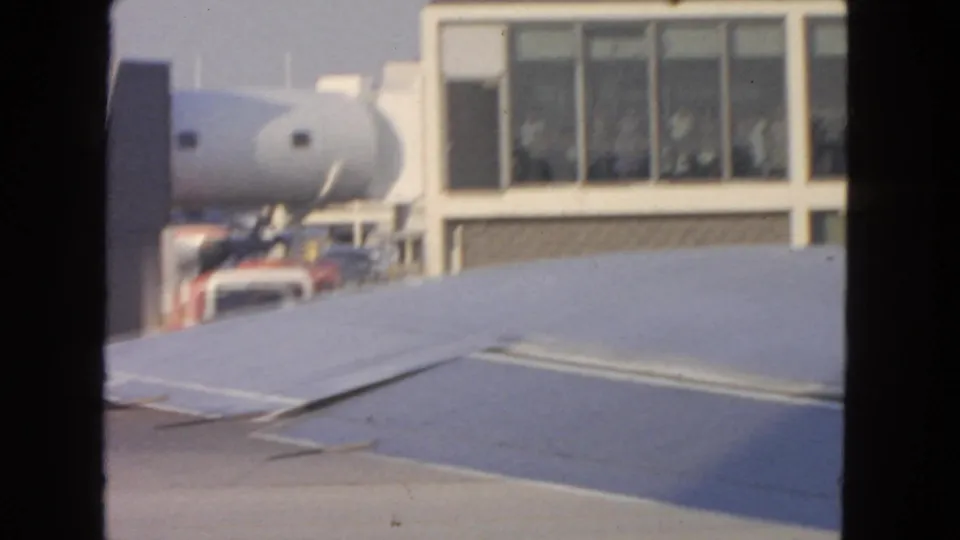 Aircraft wing and terminal windows at San Francisco International Airport in 1963, with a jet bridge visible beyond the wing.