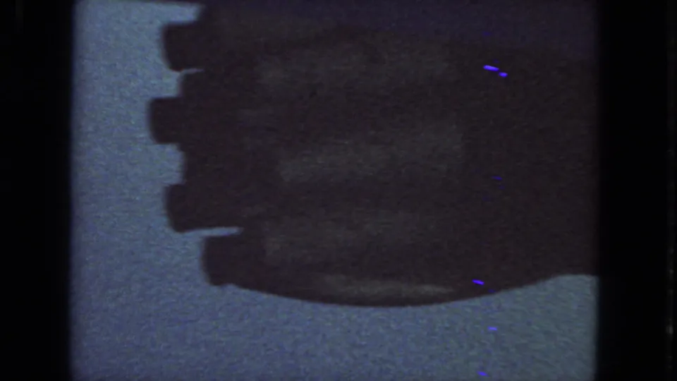 Soft 1963 8mm frame with the airplane engine area filling much of the view, seen through a darkened passenger window.