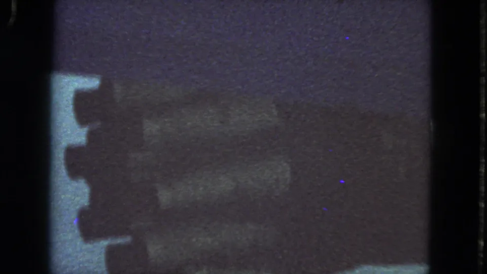 Final 1963 8mm frame showing a soft, dark close view of the airplane engine through the passenger window.