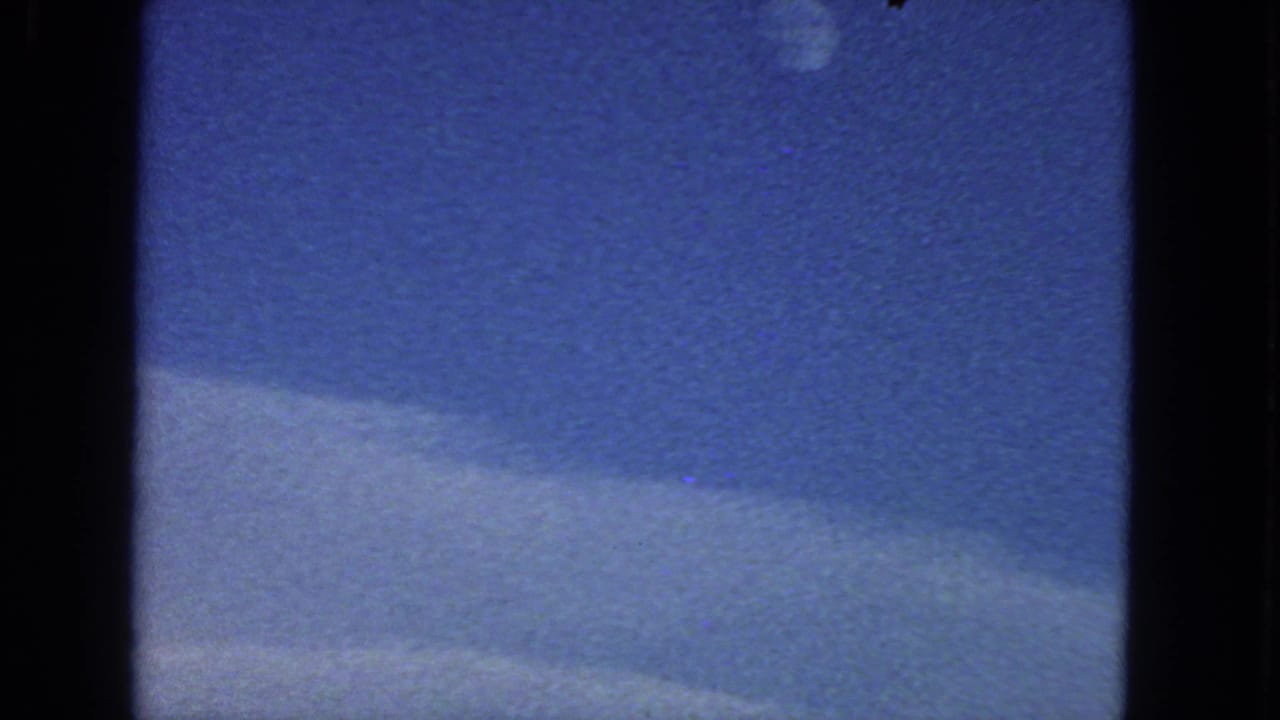 1963 8mm San Francisco-area sky view with the moon high in frame and a soft cloud band across the lower portion.
