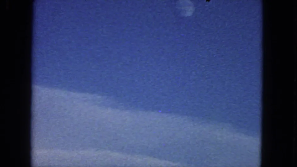 1963 8mm San Francisco-area sky view with the moon high in frame and a soft cloud band across the lower portion.