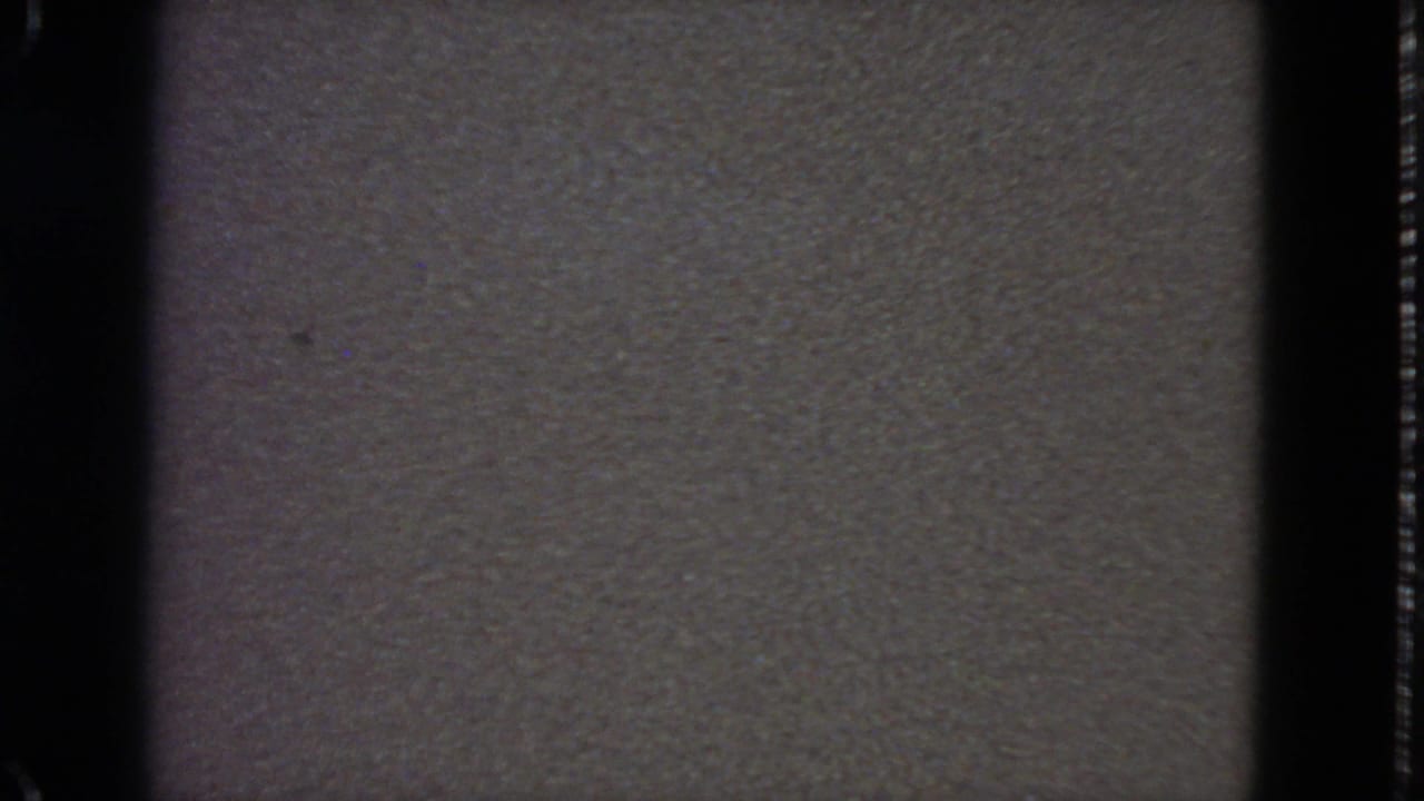 1963 8mm frame from San Francisco showing a grainy gray static-like field bordered by dark film edges.