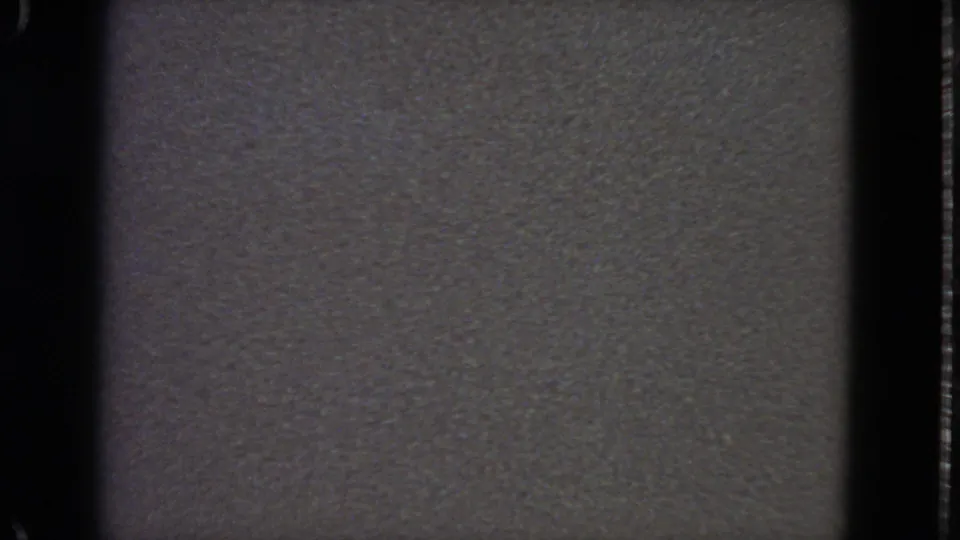 1963 8mm frame showing a low-contrast gray field, film grain, and dark gate borders with no people or objects visible.