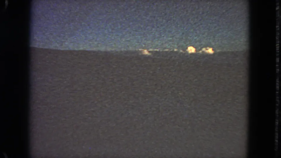 Grainy 8mm view of distant lights on a low horizon, supported by metadata as San Francisco-area footage from 1963.