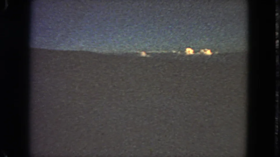 Final 1963 San Francisco 8mm frame showing scattered distant lights against a blue dusk sky and dark horizon.