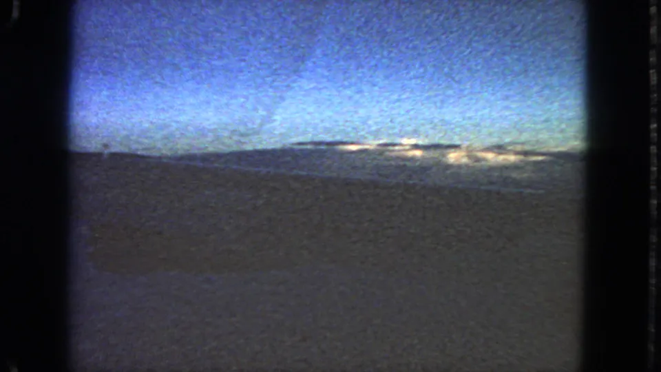 Likely San Francisco-area night view from 1963, with a brighter blue cast, dark ground, and distant lights near the horizon.