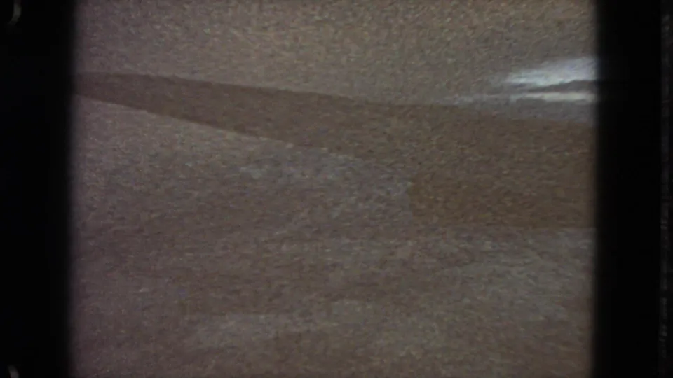 1963 San Francisco-labeled 8mm frame showing a soft, abstract light-toned surface with dark gate edges and a faint diagonal shadow.