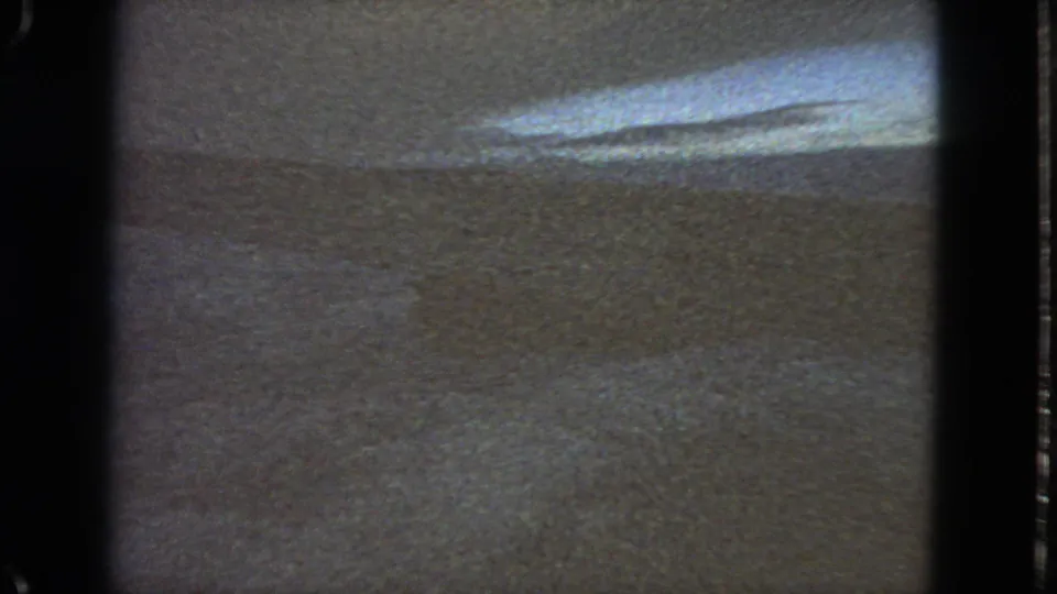 1963 San Francisco-labeled 8mm frame with a strong bright reflection over a muted textured surface and dark film-frame borders.