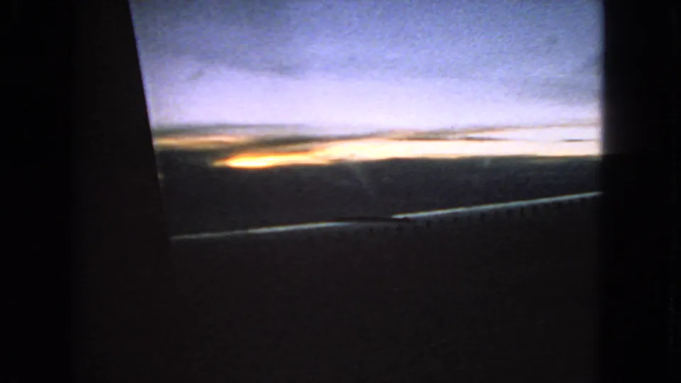 1963 San Francisco 8mm car-window frame with layered clouds, sunset light, and dark interior framing.