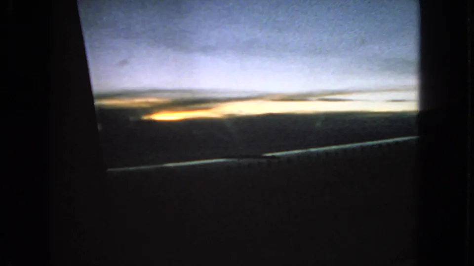 Soft 8mm view of dawn light below a blue sky, with dark foreground and window framing from supplied 1963 San Francisco metadata.
