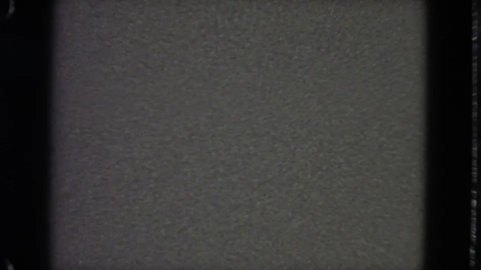 Blank 1963 8mm home-movie frame with dark gate edge, grain, and subtle surface marks.
