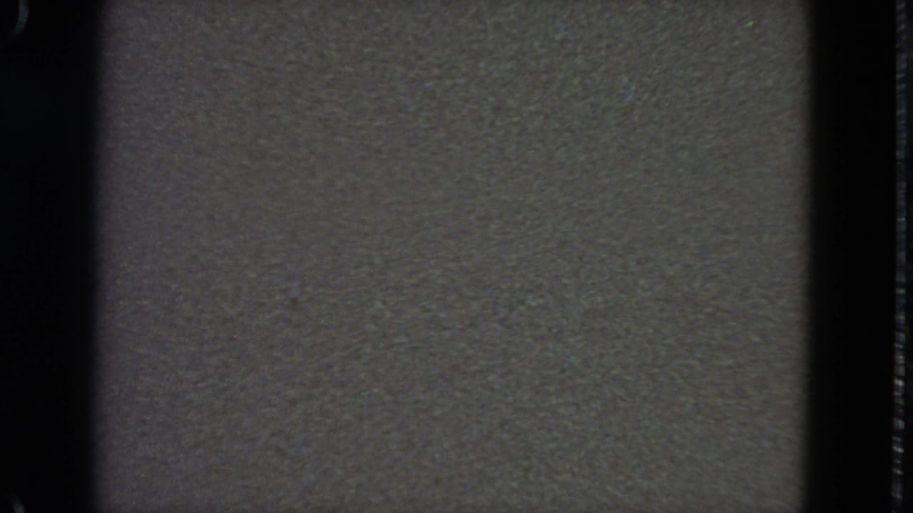 Low-contrast gray static texture framed by dark vertical film edges.