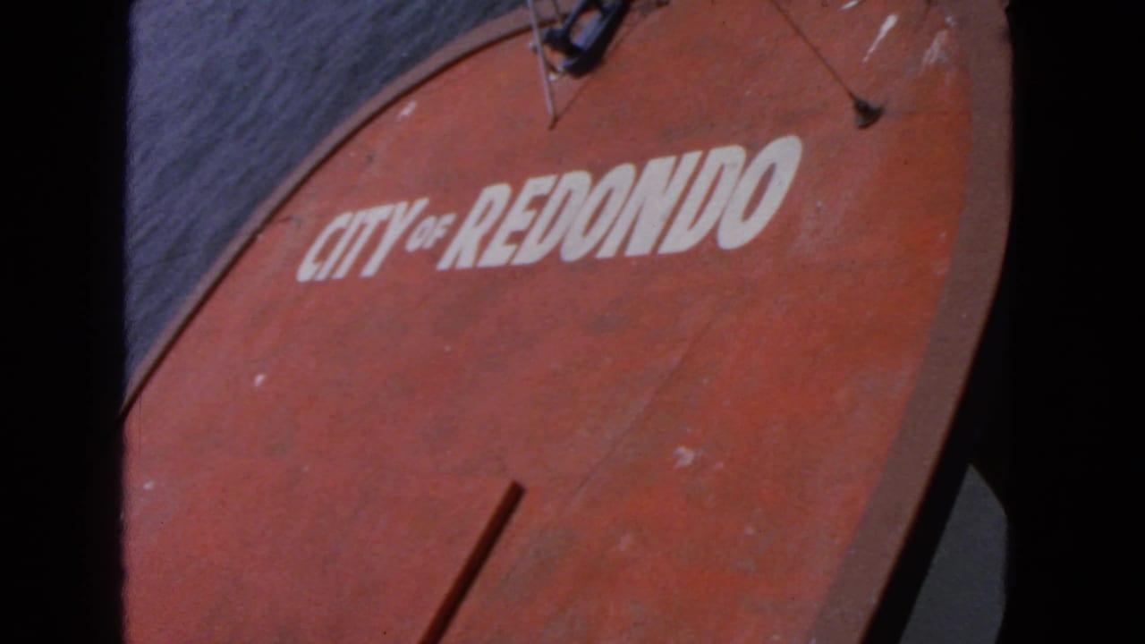 Red boat surface with white City of Redondo lettering near open water.