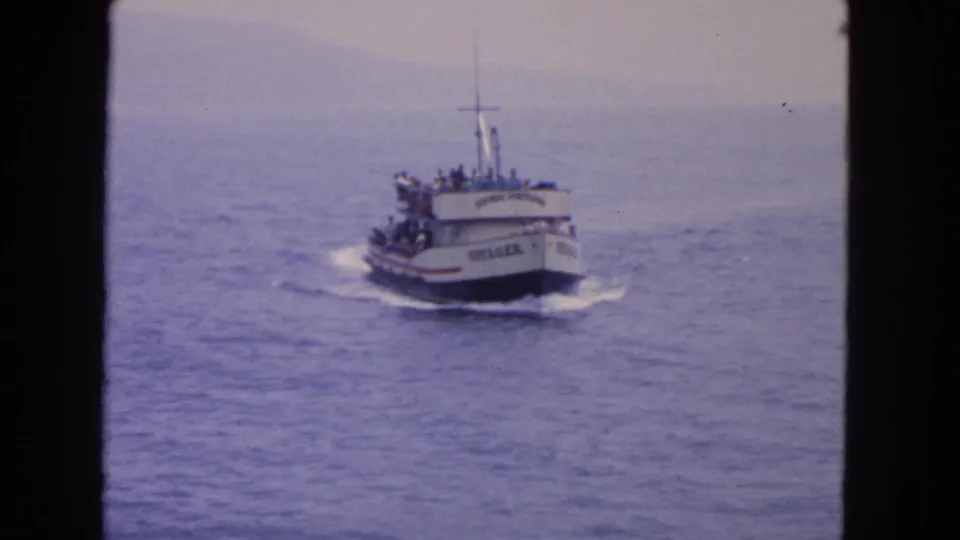 Closer 1963 home-movie view of the Voyager, its name visible as passengers gather on deck over blue water.