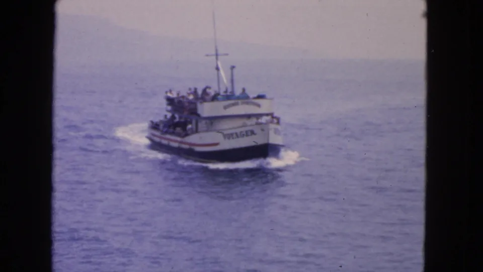 The Voyager is seen closer at an angle, with passengers along the deck and a curved wake on the water.