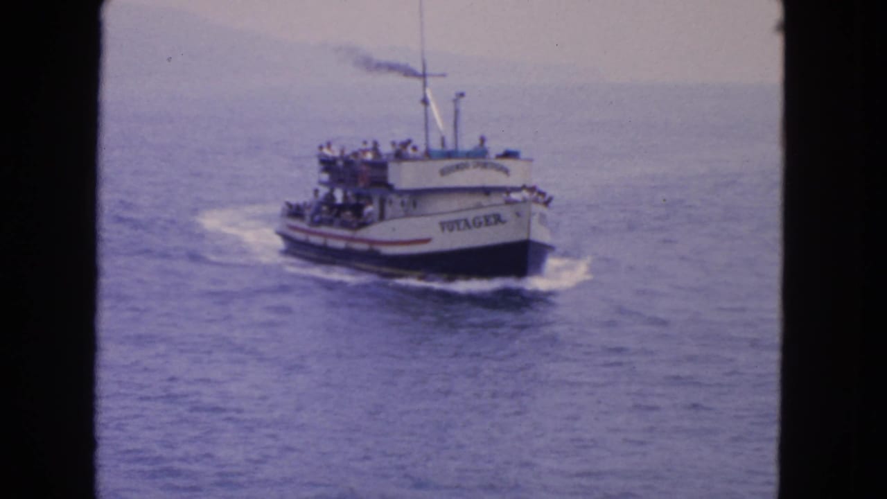 1963 home-movie frame of the Voyager passenger boat on open water near San Francisco, with riders visible on both decks.