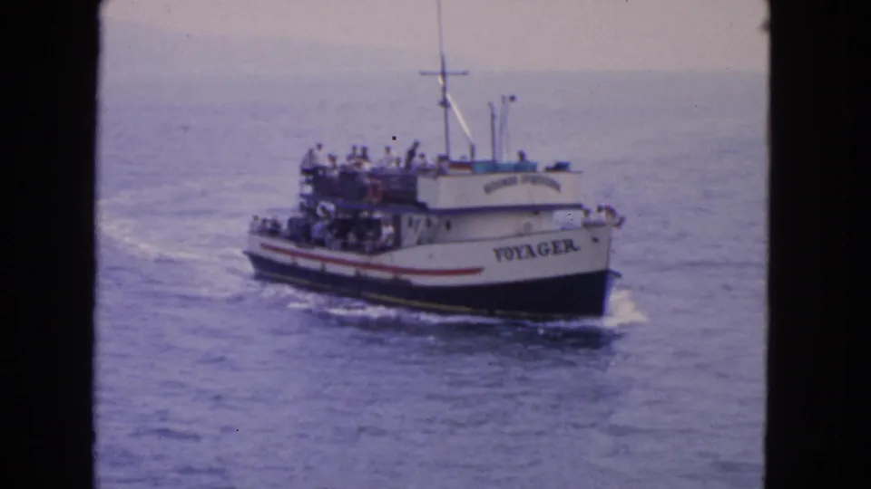 A closer side view shows the Voyager carrying passengers on open decks while cruising across water near San Francisco.