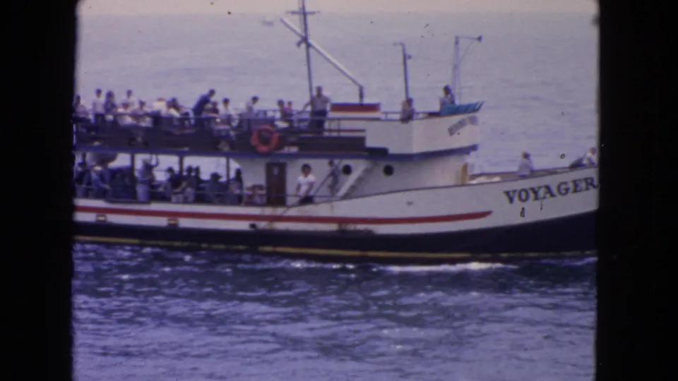 Closer 1963 San Francisco home-movie view of Voyager, showing crowded passenger decks, railings, and the vessel name near the bow.