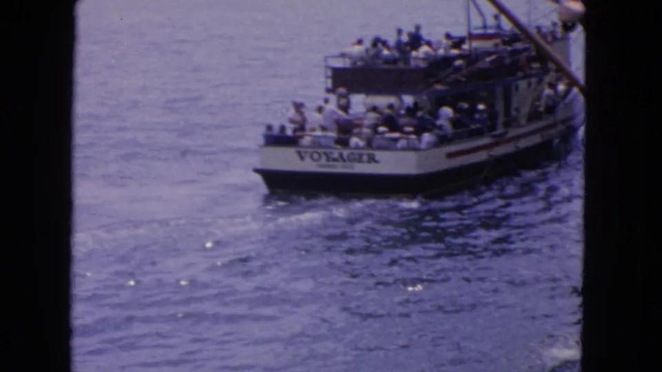 1963 San Francisco frame showing Voyager from a rear angle as passengers ride on deck and the boat leaves a small wake.