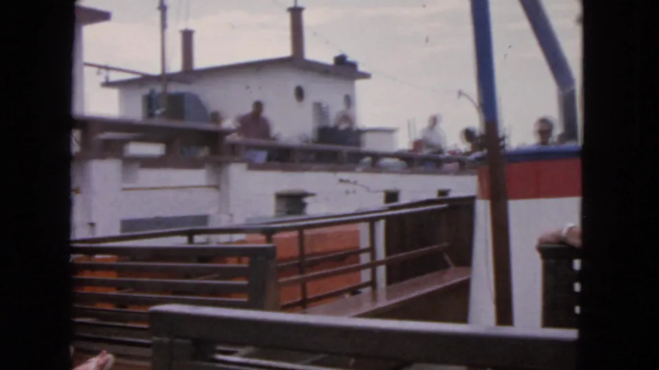 A shaky 8mm view shows railings in the foreground and passengers on a nearby vessel deck in San Francisco, 1963.