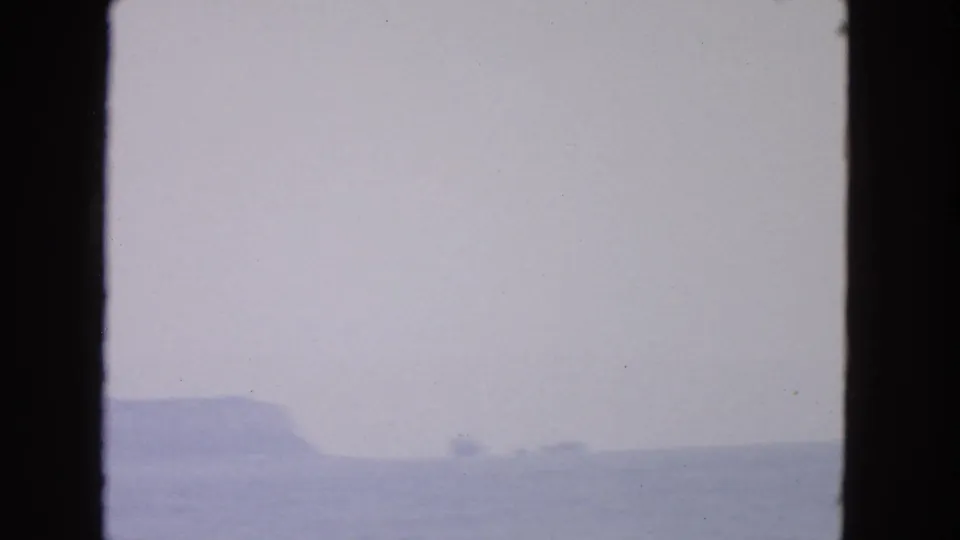 The 8mm frame holds a washed, cloudy San Francisco-area seascape with low rocks and water near the lower edge.