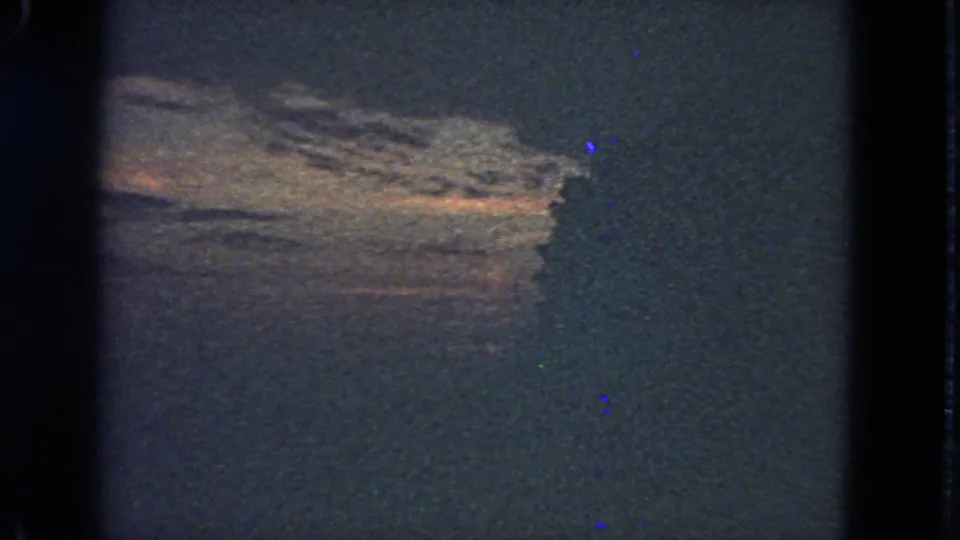 1963 San Francisco 8mm frame showing a subdued sunset sky and heavy dark silhouette in grainy exposure.