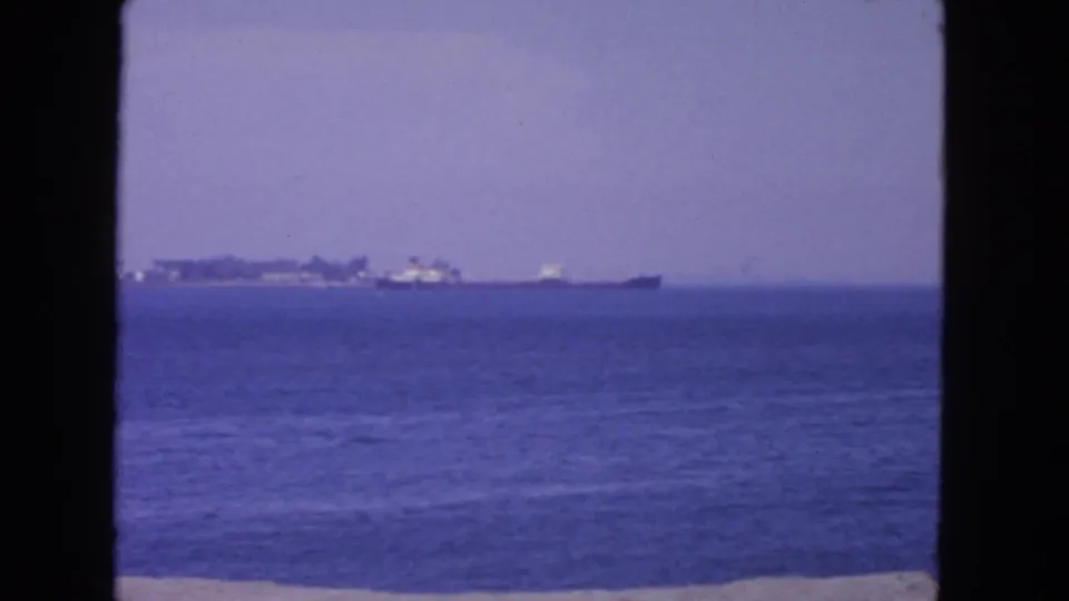 1963 San Francisco coastal view with anchored ships on the horizon, blue water, and visible 8mm frame edges.