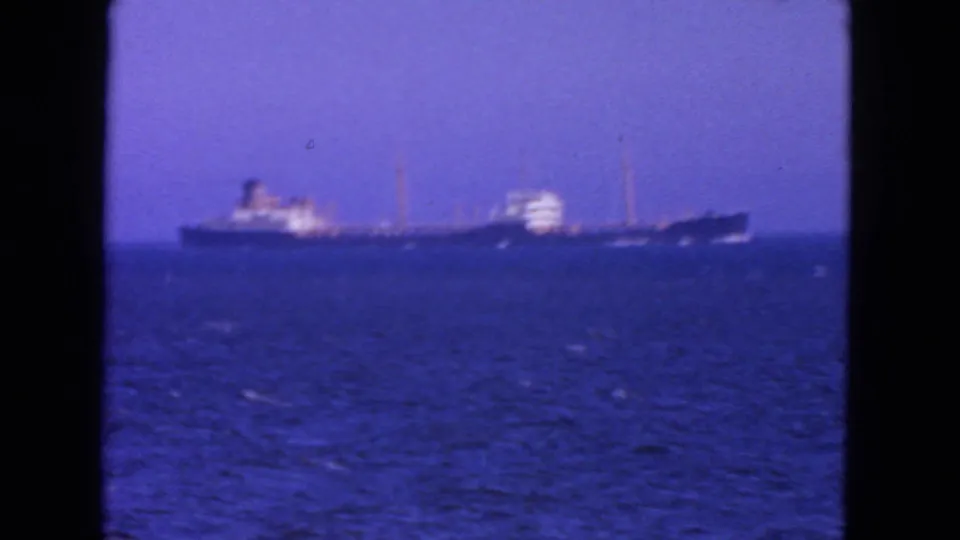 1963 San Francisco-area 8mm frame showing a distant ocean liner on open water beneath a clear blue sky.