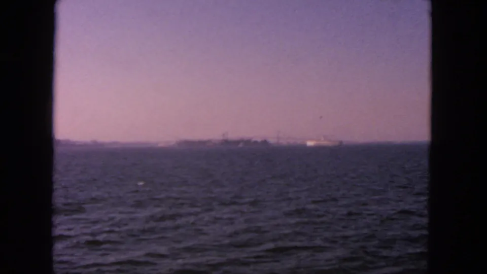 End frame of the 1963 San Francisco Bay view, showing rippled water and a hazy distant shoreline without the ship visible.