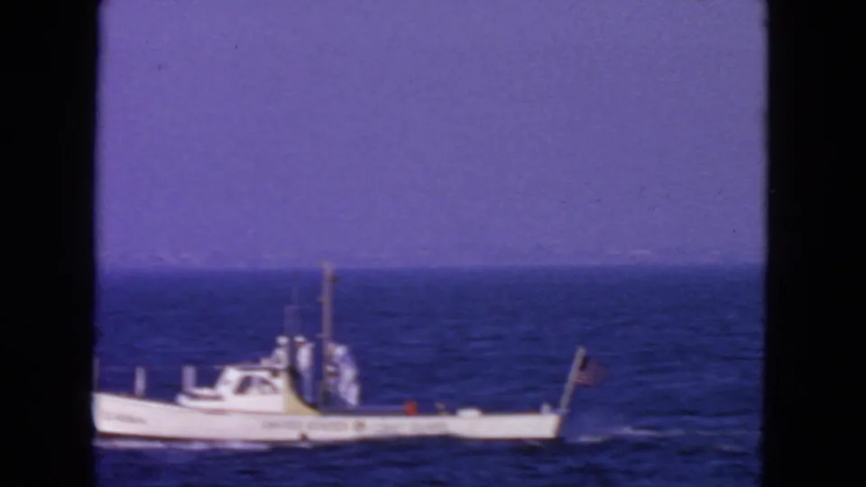 Distant 1963 San Francisco footage shows a small Coast Guard vessel moving across choppy blue water.