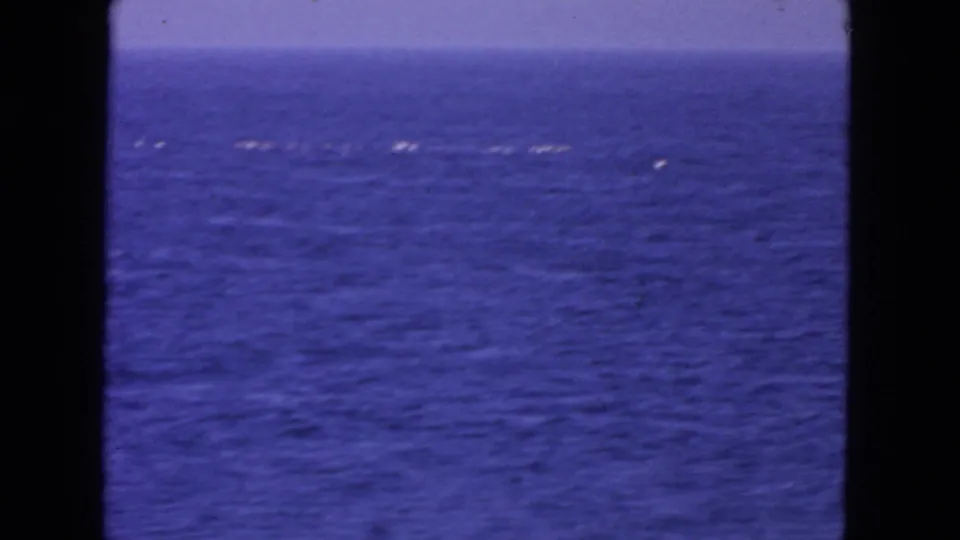 1963 8mm ocean view near San Francisco, showing blue water, pale horizon, and scattered white foam or reflected highlights.