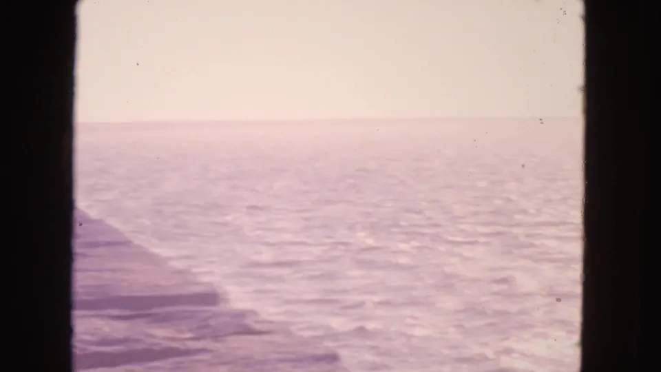 Open San Francisco ocean view on 8mm film, with a faint stone edge, soft haze, and dark vertical framing.