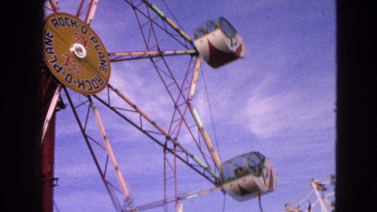 Rock-O-Plane wheel gondolas rotate against a blue sky.