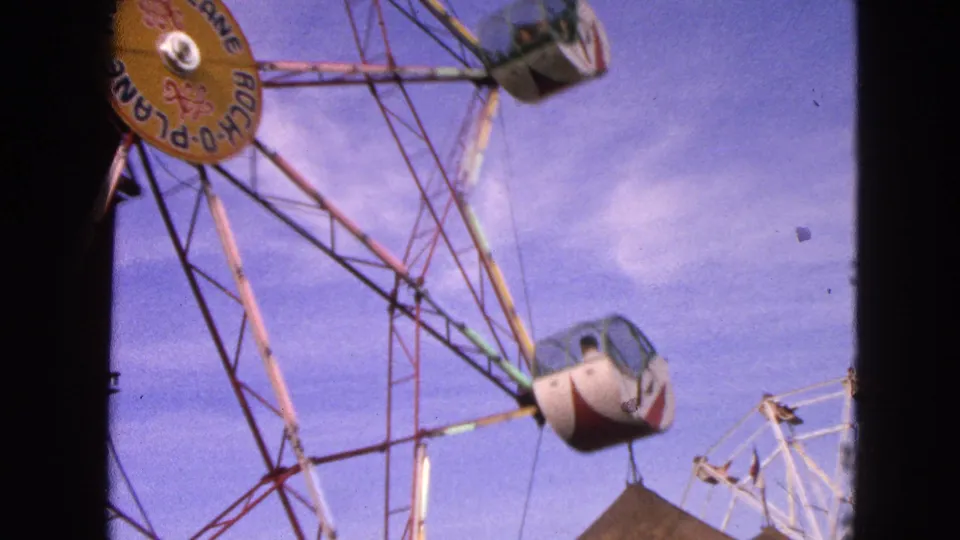 The Rock-O-Plane wheel continues rotating in Walworth, Wisconsin, with gondolas suspended from its colored metal structure.