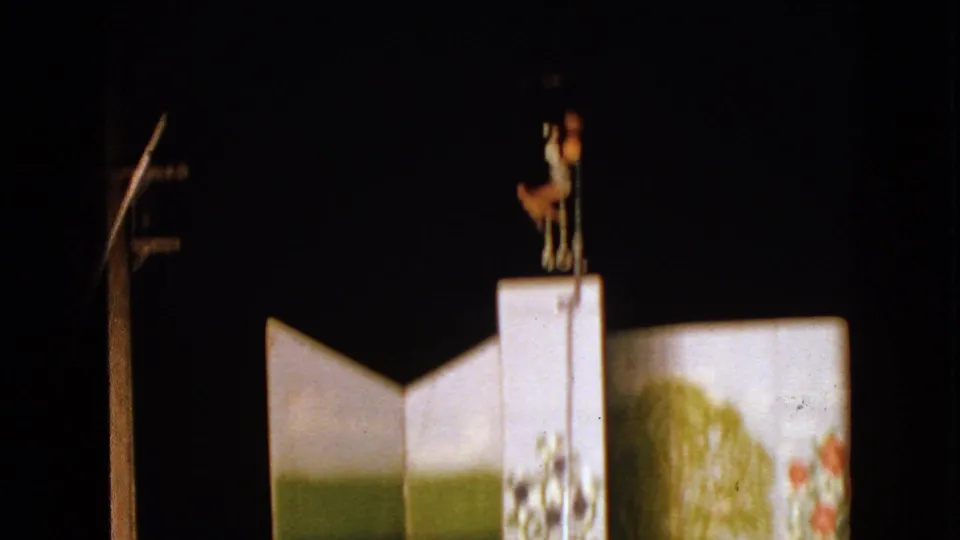 1963 Walworth, Wisconsin 8mm frame showing the aerial performer upright on the white platform, with painted panels below.