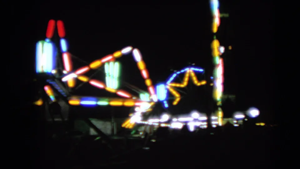 A closer 1963 fair view shows colorful ride lights, a star-like light pattern, and bright bulbs blooming on 8mm film.