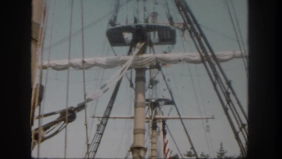 1962 Disneyland California frame with pirate-ship rigging, a crow's nest, pale sky, trees, and an American flag near the lower edge.