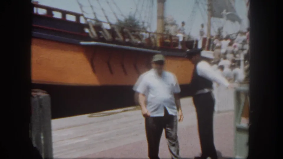 The final frame shows the docked sailing vessel at Disneyland with a visitor in a green hat, an attendant, rigging, and the ship hull in view.
