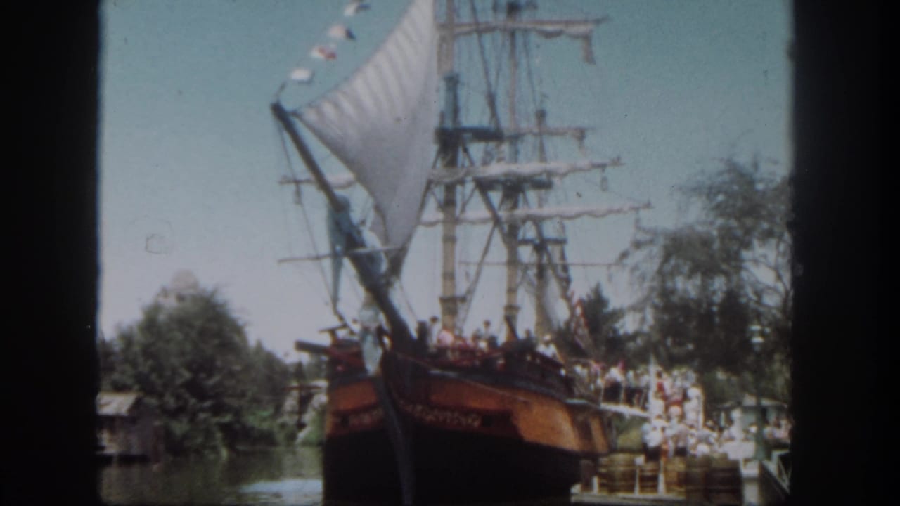 Disneyland, California frame from 1962 showing guests aboard a large ship attraction near a crowded boarding area.