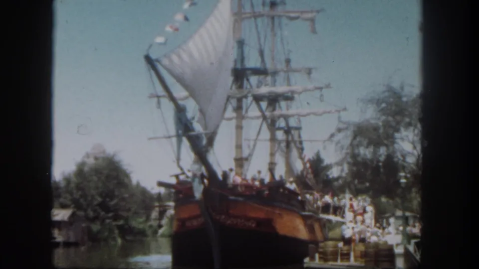 Disneyland, California frame from 1962 showing guests aboard a large ship attraction near a crowded boarding area.