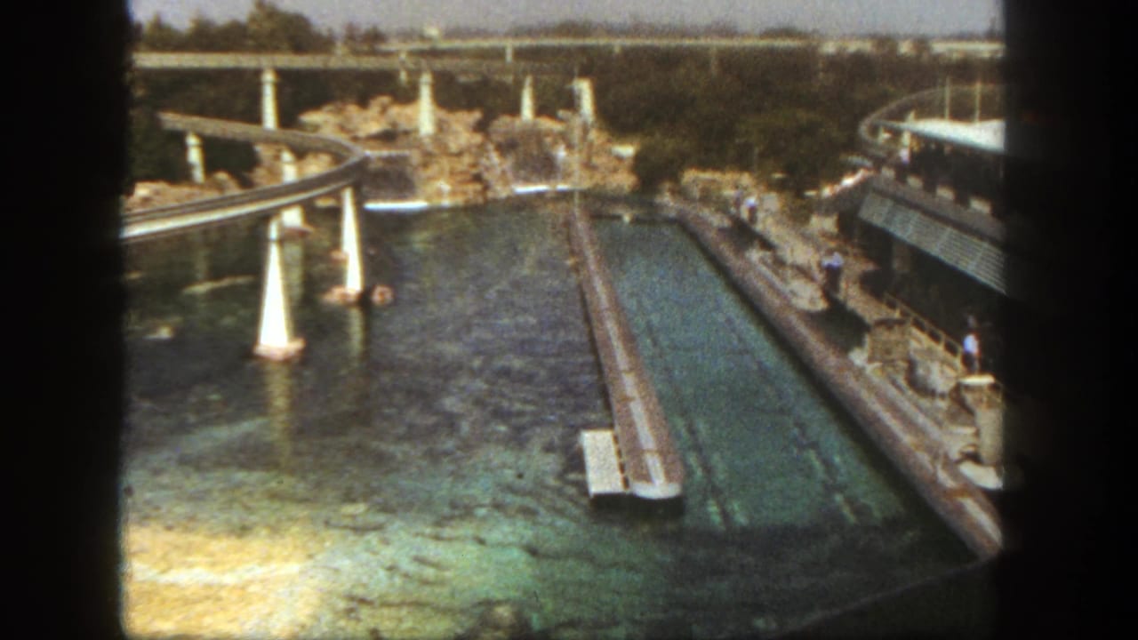 Overhead park view with water channels, rockwork, walkways, and a raised track.