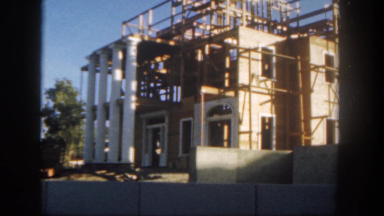 Scaffolded building with white columns behind construction barriers.