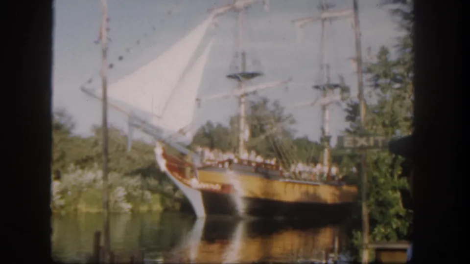 The 1962 Disneyland California home movie shows the sailing ship continuing past calm water and planted shoreline scenery.