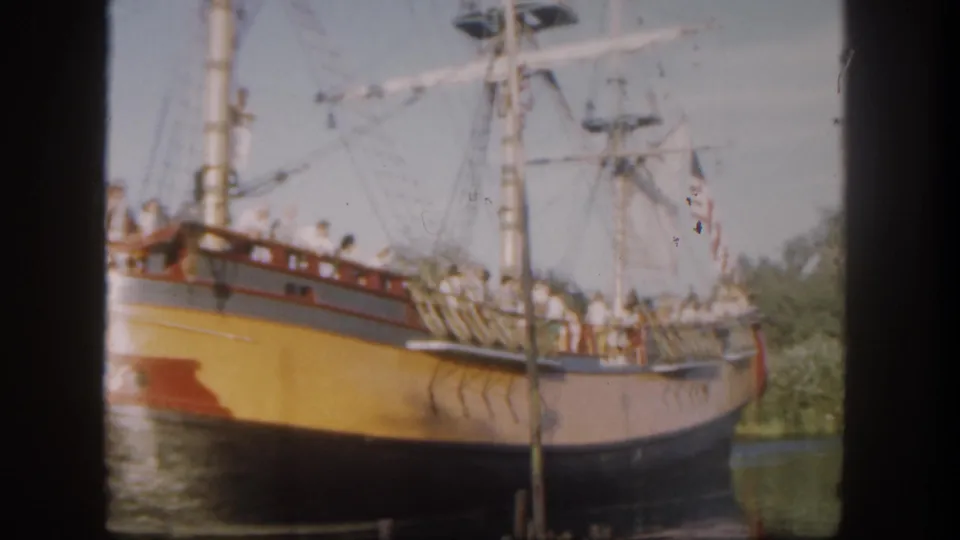 Final 1962 Disneyland home-movie frame showing the sailing ship continuing through the waterway with guests on deck.
