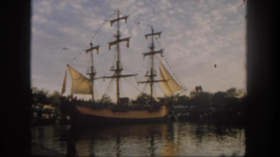 Faded 8mm frame of a Disneyland sailing ship attraction, seen from a shaded visitor vantage in 1962.