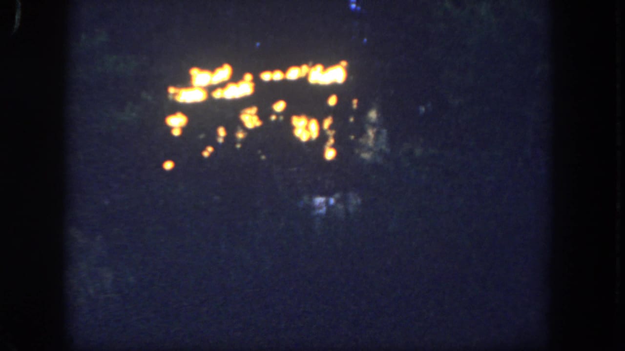 Warm scattered lights glow against a very dark, grainy background.